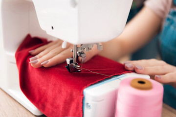 Close up of sewing machine. Girl at garment factory is sewing new dress.