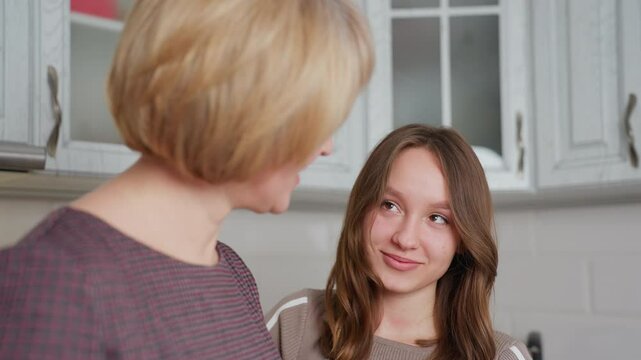 Aunt and child share a heartfelt moment in kitchen, exchanging warm smiles and affectionate glances, their bond is evident as they enjoy spending quality time together