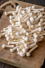 Fresh white beech mushrooms elegantly arranged on a rustic cutting board