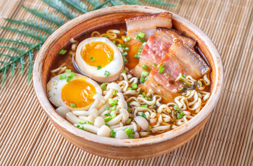 Hearty rustic ramen bowl with pork belly, beech mushrooms, and ramen eggs