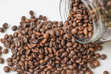 Coffee beans spilling out of a glass jar