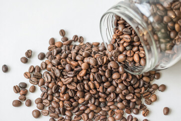 Coffee beans spilling out of a glass jar