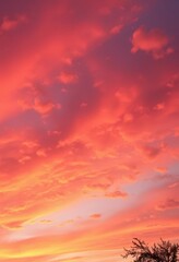 Fototapeta premium Fiery orange and pink sunset hues paint a summer sky, clouds ablaze with color, vacation, atmospheric