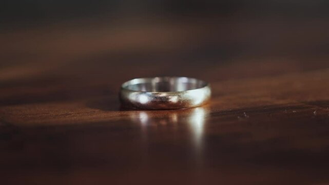 Close-up of hand tossing a wedding ring on a table. Scene announcing a divorce. Divorced family concept. High quality 4k footage