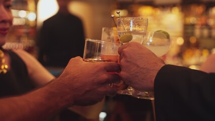 Cropped in friends group or couple making a toast with drinking cocktail in Paloma, Margarita, Old fashioned and Martini, celebrating special party at nightclub, focusing on beautiful woman. Vinosity.