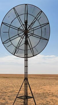 Unique wind turbine stands alone in vast desert under clear blue sky