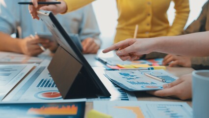 A dynamic office scene showcasing a diverse group of professionals engaged in a collaborative meeting. Focused on charts, reports, and digital devices for effective data analysis. SACTR