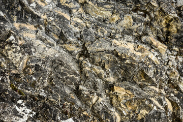 Stone texture with grey, black and yellowish veins. Natural pattern typical of rocks.
