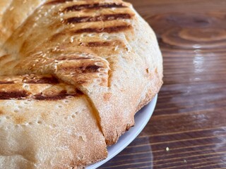 A Deliciously Freshly Baked Flatbread Featuring EyeCatching Grilled Patterns on Top. This scrumptious, golden brown flatbread features distinct and unique grill marks, making it ideal for any meal