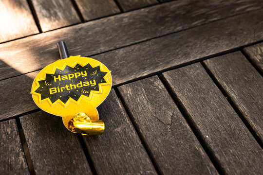At party, birthday party badge on wooden table, ready for festive celebration, in garden, copy space