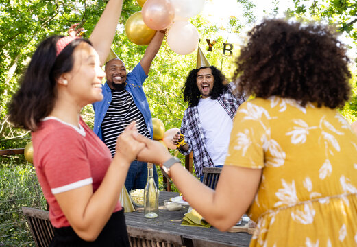 At party, Celebrating on deck, diverse friends with balloons smiling at festive party together