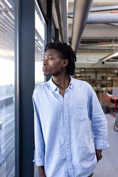 Confident professional in office looking out window, contemplating new opportunities
