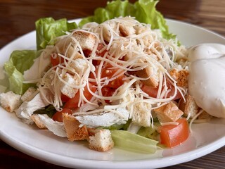 A Freshly Rendered Salad made with Crisp Lettuce and a Deliciously Creamy Dressing. A vibrant and colorful plate of fresh salad featuring tender shredded chicken, crisp lettuce, and a creamy side