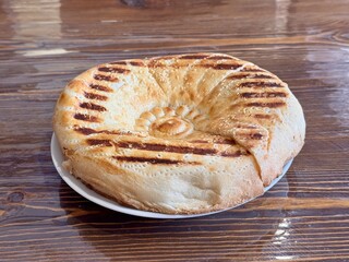 A Deliciously Freshly Baked Flatbread Featuring EyeCatching Grilled Patterns on Top. This scrumptious, golden brown flatbread features distinct and unique grill marks, making it ideal for any meal