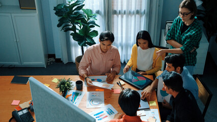 Top view of skilled business team discussing and talking about financial statistic to make decision for investment. Creative project manager looking at data analysis from laptop screen. Convocation.