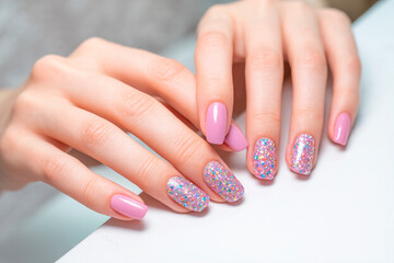 Creative manicure with gel polish in a luxury beauty salon, Nail art and design, French manicure, Fingers of a young woman's hand with beautiful pearlescent nail polish,