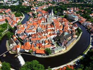 Panorama of Cesky Krumlov, Czech Republic. Red roofs and old medieval houses, water of Vltava River. View from drone, Krumlov