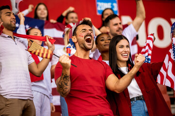 American football, soccer fans cheering at the stadium with flags and other equipment