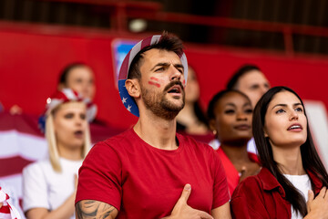 American football,  soccer fans singing anthem at the stadium.