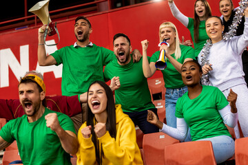 Fototapeta premium Football, soccer fans are cheering for their team at the stadium on the match.