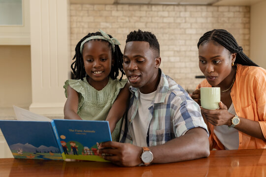 Reading storybook together, African American family at kitchen table, quality time