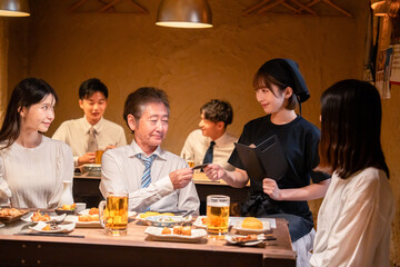 居酒屋でキャッシュレス決済をする男性客