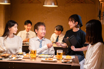 居酒屋でキャッシュレス決済をする男性客