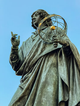 Pomnik Mikołaja Kopernika, posąg astronoma w Toruniu. Rynek toruński, ratusz. Monument of Nicolaus Copernicus, astronomer, heliocetner, model of the Universe. copy space. Poland, Torun.