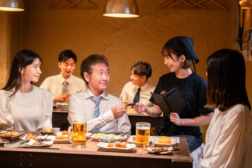 居酒屋でキャッシュレス決済をする男性客