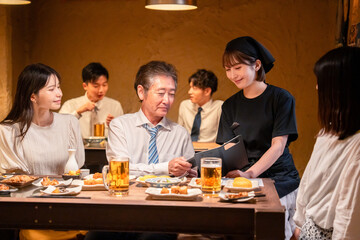 居酒屋でキャッシュレス決済をする男性客