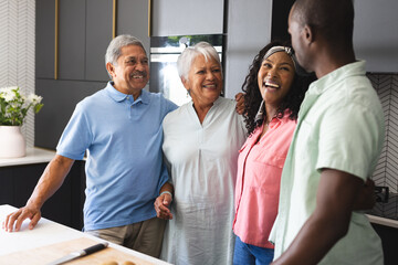 In kitchen, multigenerational family spending quality time , smiling warmly, at home