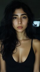 A beautiful woman is looking directly at the camera with a serious expression