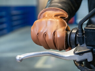 close-up of a motorcyclist's hand dressed in a brown leather glove