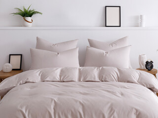 Bedroom with white walls, wooden floors, and handmade furniture. Double bed with four pillows is made up with a fluffy duvet in a beige duvet cover. Front close-up view photo. Suitable for mockup