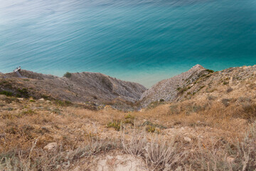 A stunning view of the seascape from a steep rocky cliff, the azure surface of the Black Sea in the hot sultry summer in the Krasnodar region of the tourist city of Anapa.