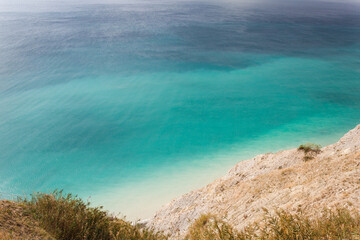 A stunning view of the seascape from a steep rocky cliff, the azure surface of the Black Sea in the hot sultry summer in the Krasnodar region of the tourist city of Anapa.