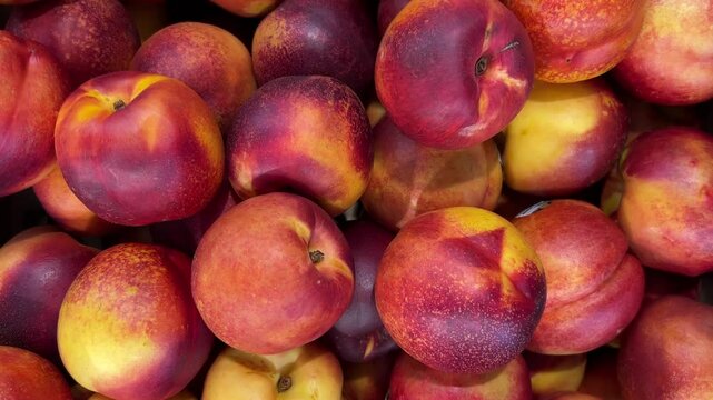 Nectarine peaches in crate displayed in supermarket, slider tracking shot in top view on nectarine peaches