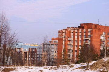 A small red brick building sits atop a snow-covered hill, providing a cozy and inviting scene.