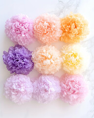 Pastel paper pom-poms arranged on marble