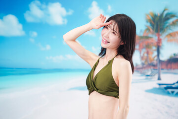 Naklejka premium 青空のビーチで水着を着た若い女性