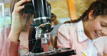 In school, students using microscope and laughing, enjoying science class activities