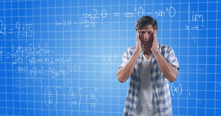 Confused man holding head, standing in front of complex math equations