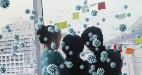 Team brainstorming on glass board with digital virus overlay concept