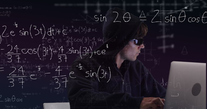 Hacker in hoodie using laptop with complex math equations on screen