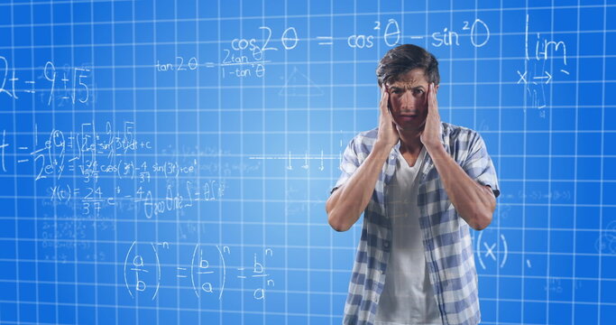 Confused man holding head, standing in front of complex math equations