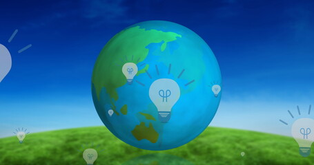 Image of light bulbs and globe spinning over landscape
