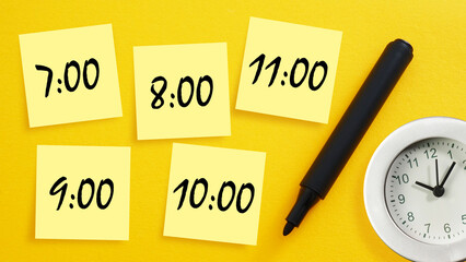 Planning day concept, schedule. Sticky notes with time on work desk. Student's and work time schedule