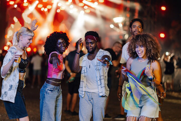 Friends dancing and enjoying music festival at night