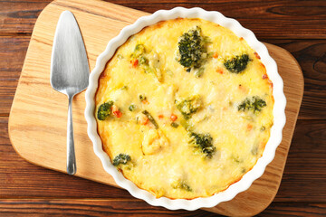 Delicious vegetable casserole and server on wooden table, top view
