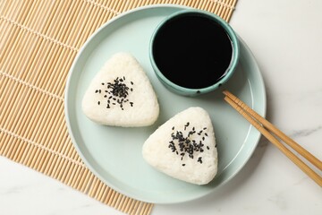 Rice balls (onigiri) served on light table, top view. Traditional Japanese dish